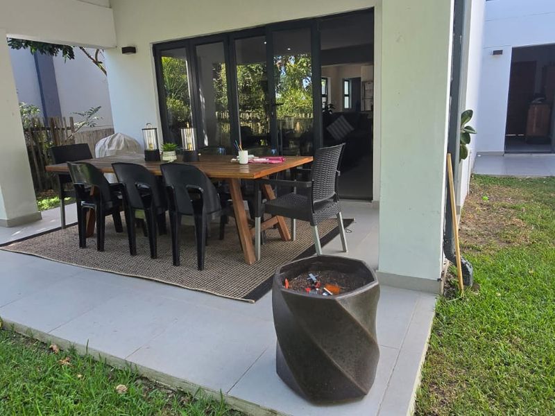 A covered outdoor patio area featuring tiled flooring and large sliding glass doors providing seamless access to the interior living space.
