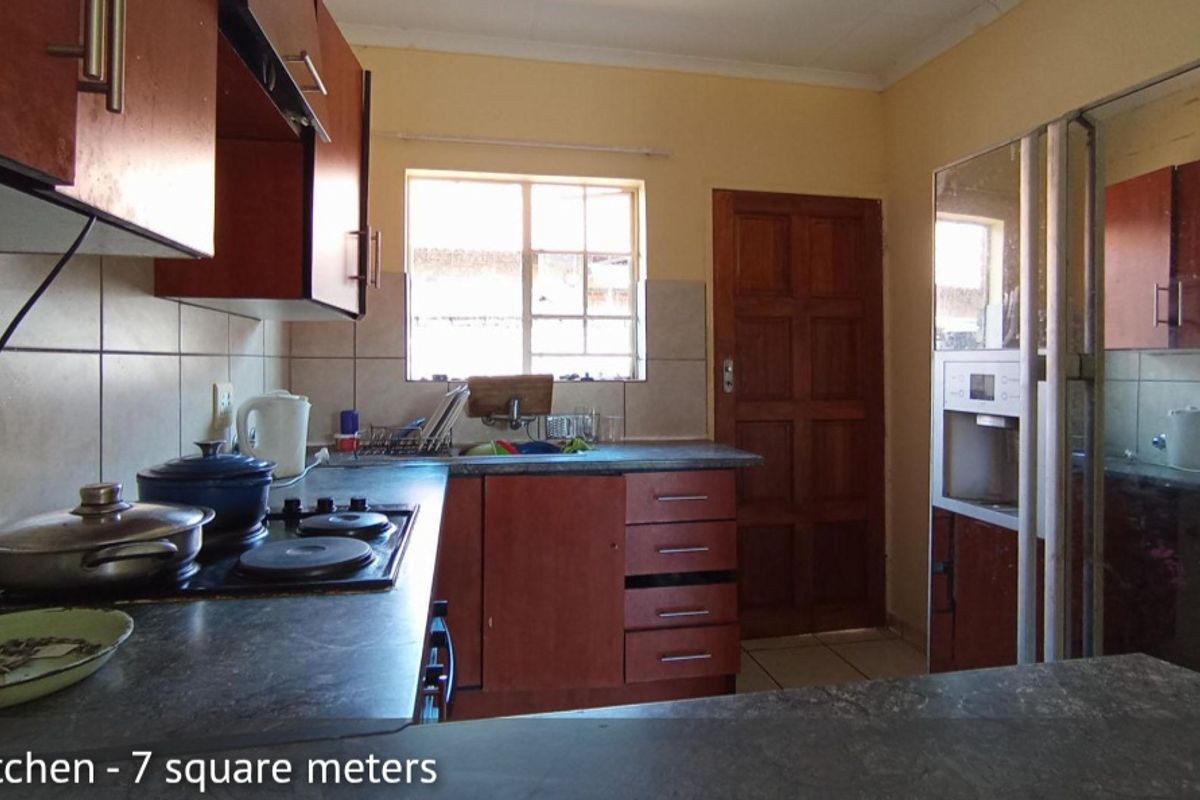 A functional kitchen featuring built-in wooden cabinetry, laminate countertops, a built-in hob, and tiled splashbacks.