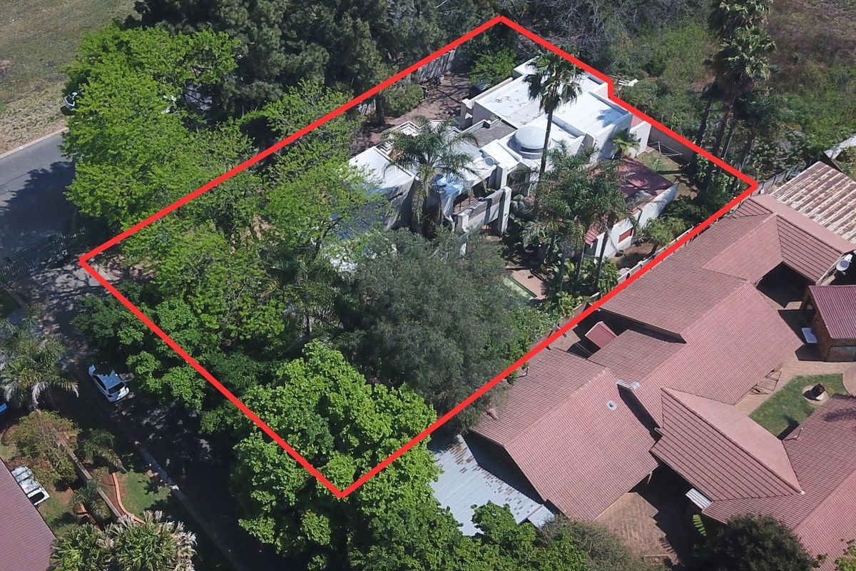 Aerial view of the property highlighting the building footprint, mature garden landscaping, and surrounding residential context.