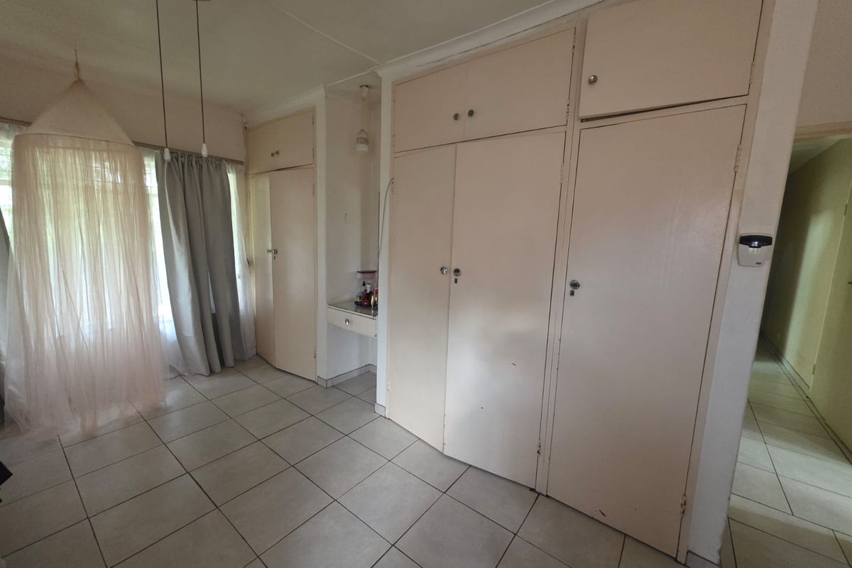 Bedroom featuring built-in floor-to-ceiling cabinetry and tiled flooring, offering ample storage space.