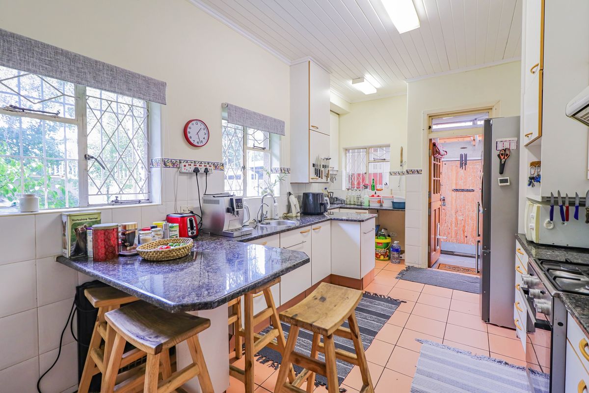 A functional kitchen featuring granite countertops, built-in cabinetry, a breakfast nook, and direct access to an exterior door.