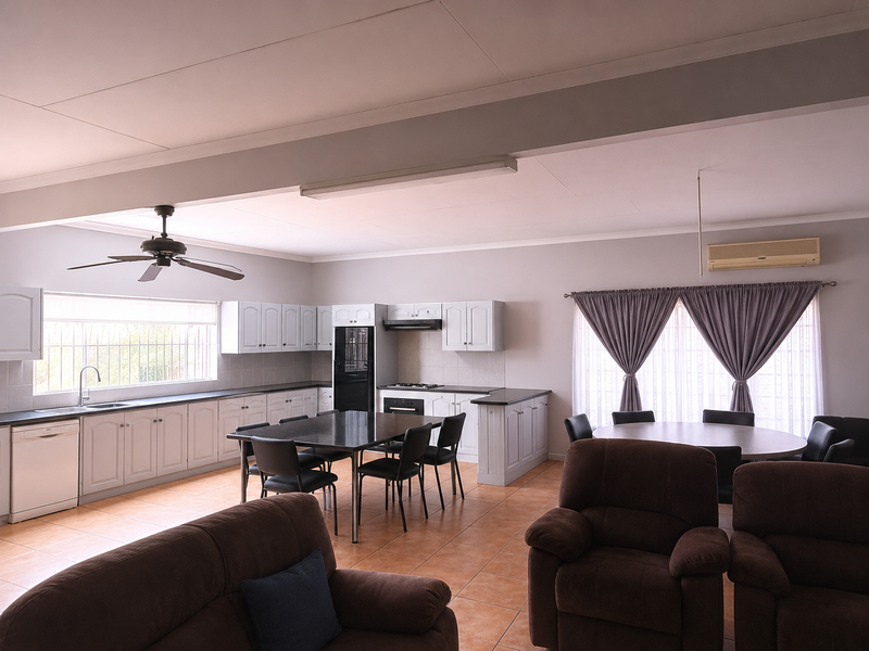 Spacious open-plan kitchen and living area featuring tiled floors, neutral cabinetry, built-in appliances, ceiling fan, and split-system air conditioning.