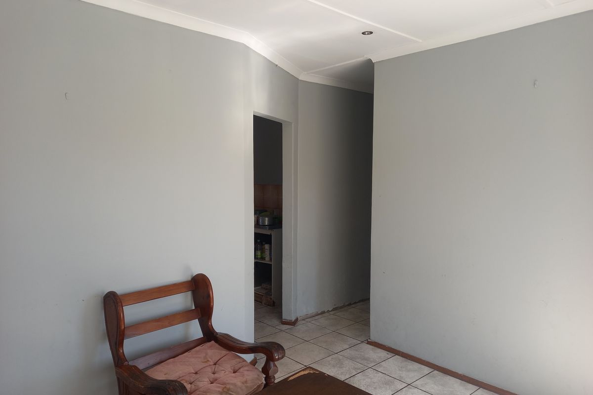 A view of an interior living space featuring tiled flooring and a doorway leading to an adjacent room.