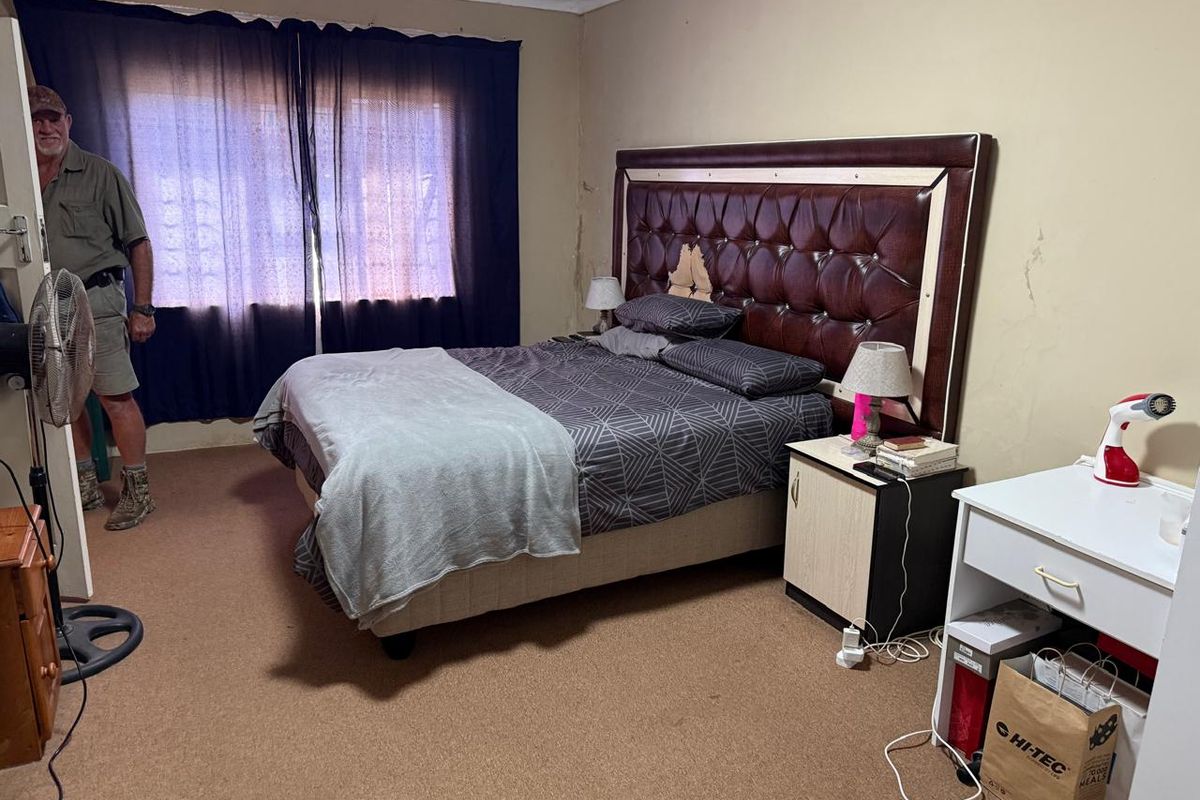 A bedroom featuring carpeted flooring and visible wall surface deterioration, requiring cosmetic updates to improve the overall condition of the space.