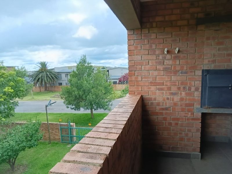 A covered balcony featuring a built-in brick braai and views over the surrounding neighbourhood.