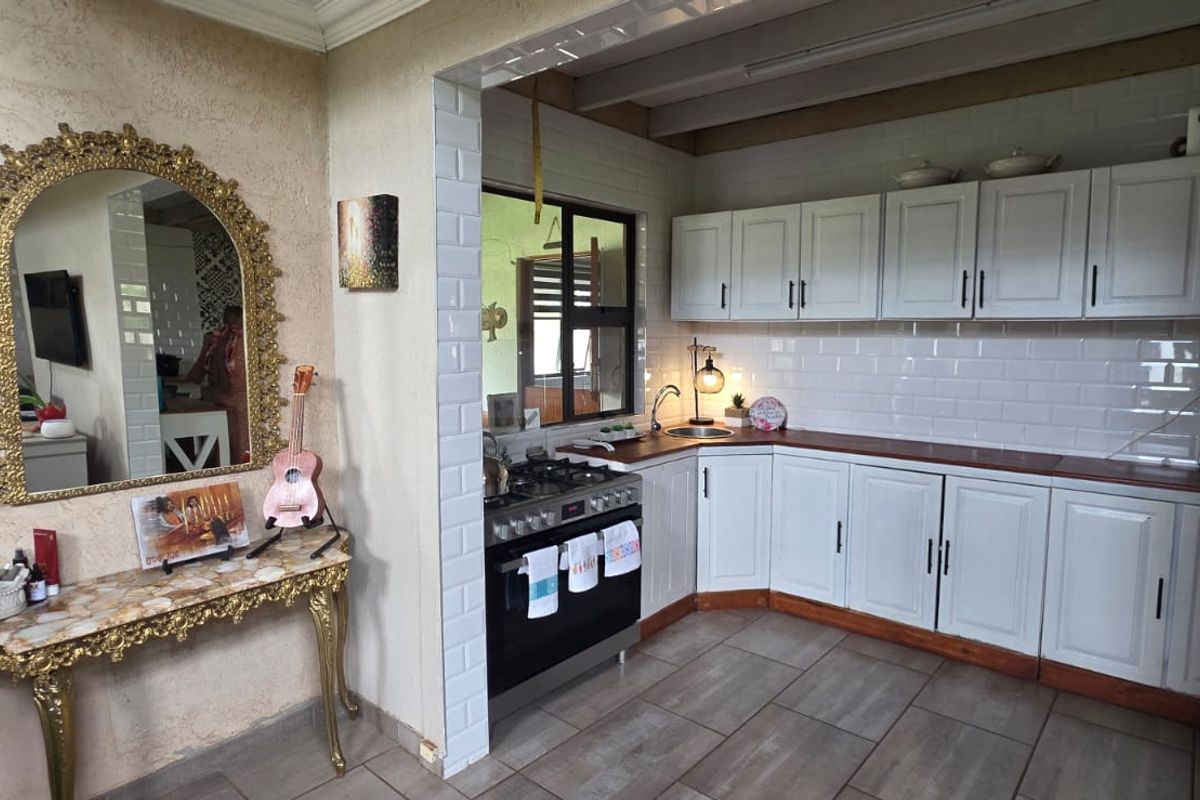 A functional kitchen featuring white cabinetry, subway tile backsplash, wooden countertops, and a built-in gas stove, adjacent to a decorative entryway area.