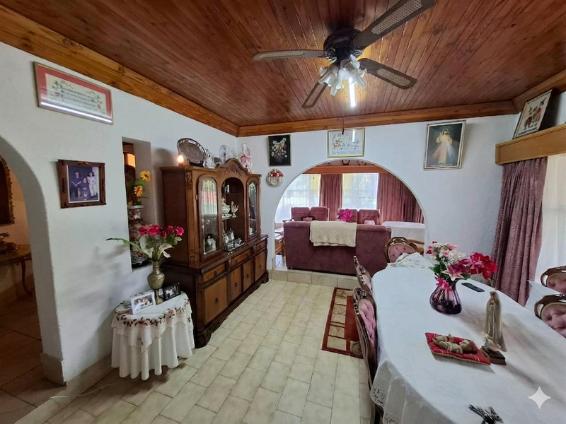 Dining room featuring a timber tongue and groove ceiling, ceiling fan, and arched transitions leading to an adjacent living area.