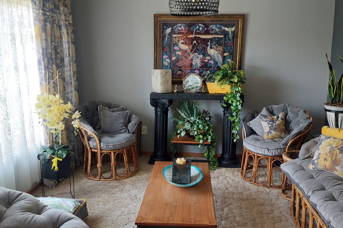 A cozy living room featuring neutral wall tones, plush carpeting, and decorative pendant lighting, creating a comfortable and inviting atmosphere.