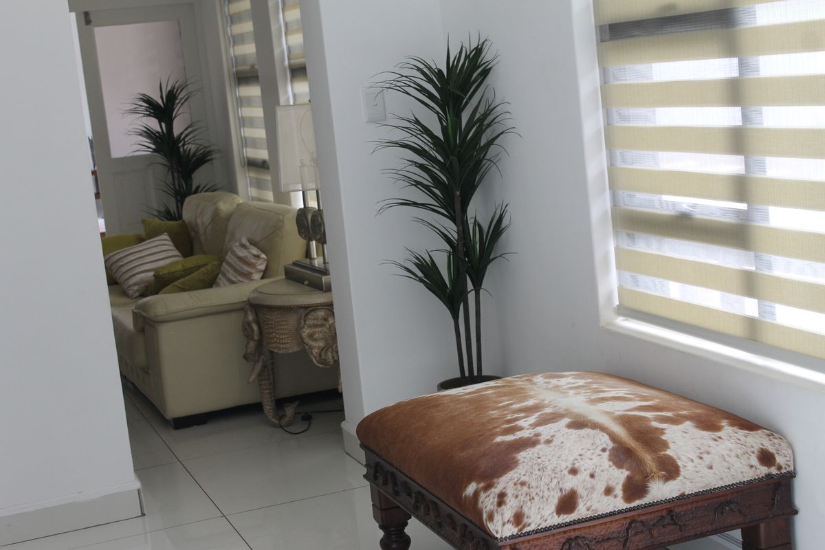 A bright living area featuring tiled flooring and modern dual-layer roller blinds, creating a clean and contemporary atmosphere.