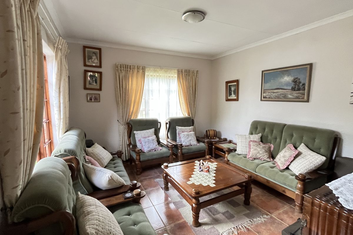 A comfortable living room featuring tiled flooring and large windows that provide natural light, creating a warm and inviting atmosphere.