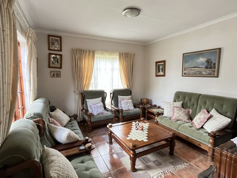 A comfortable living room featuring tiled flooring and large windows that provide natural light, creating a warm and inviting atmosphere.