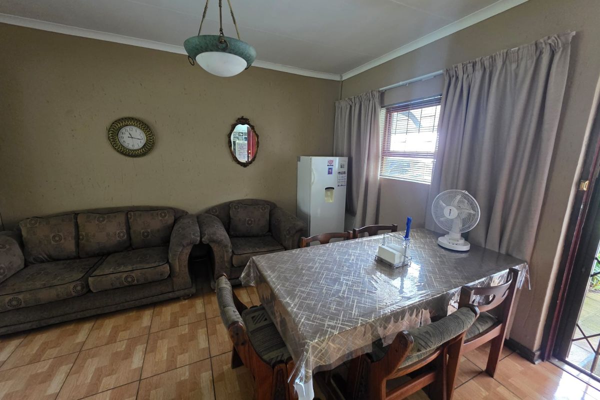 A combined living and dining area featuring tiled flooring and neutral wall tones, offering a functional space ready for modern updates.