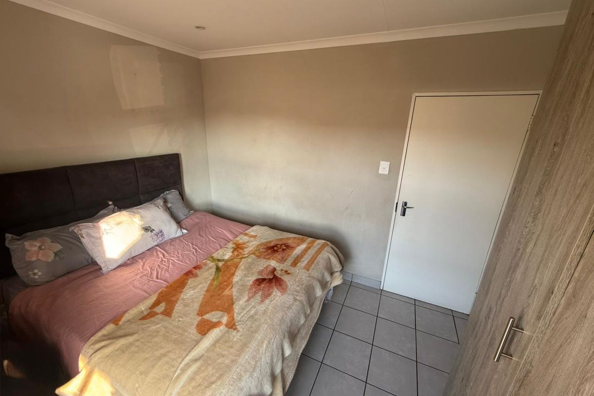 A functional bedroom featuring tiled flooring, built-in cabinetry, and recessed ceiling lighting.