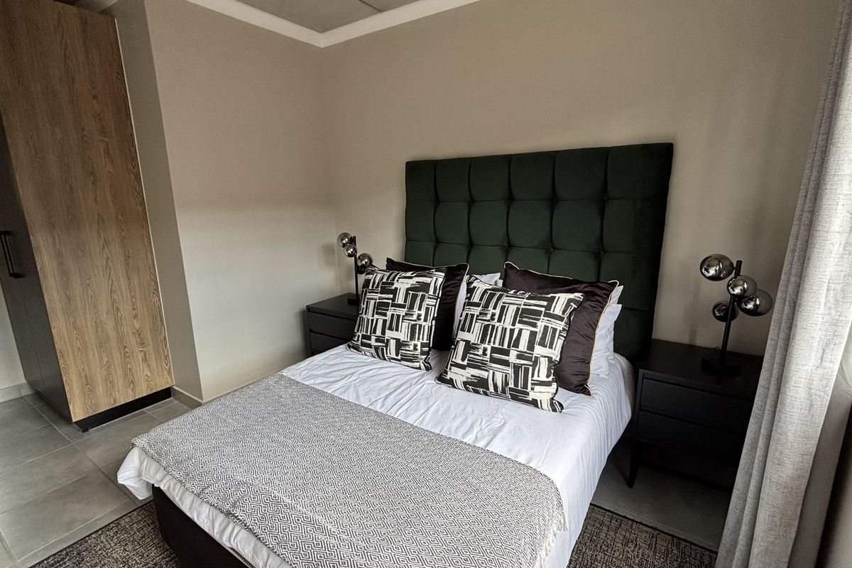 A well-maintained bedroom featuring built-in wooden cabinetry and neutral wall finishes, providing a clean and functional living space.
