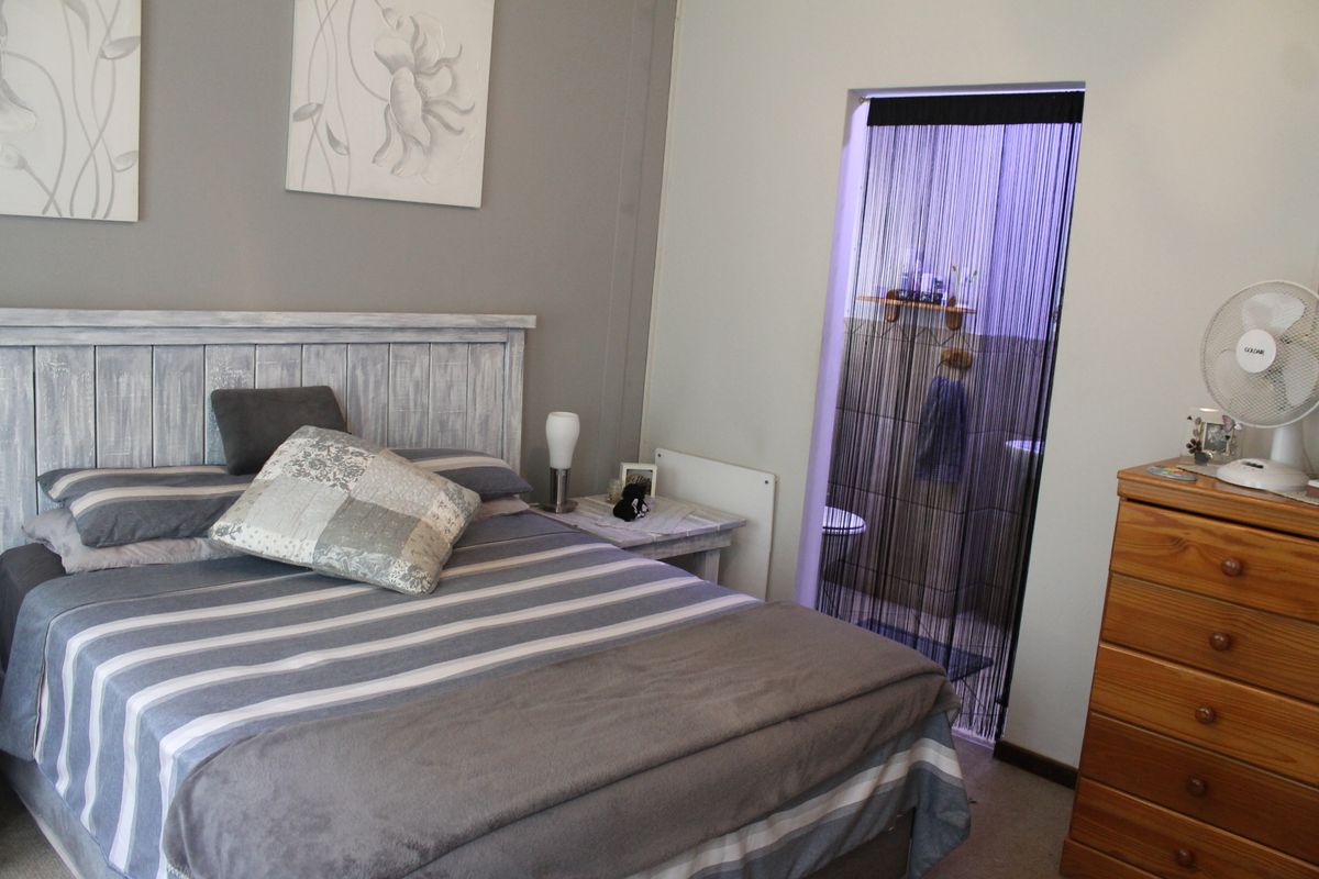 A bedroom featuring a neutral color palette and direct access to an en-suite bathroom.