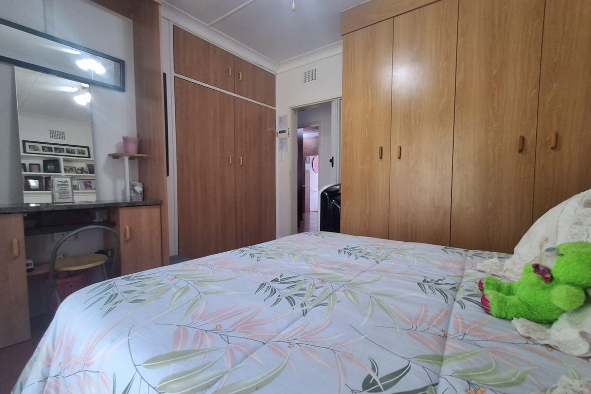 Bedroom featuring extensive built-in wooden cabinetry, including a vanity unit and floor-to-ceiling wardrobes, providing ample storage space.