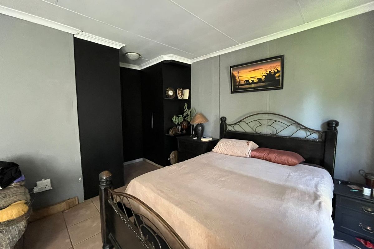 A bedroom featuring built-in black cabinetry, tiled flooring, and crown molding.