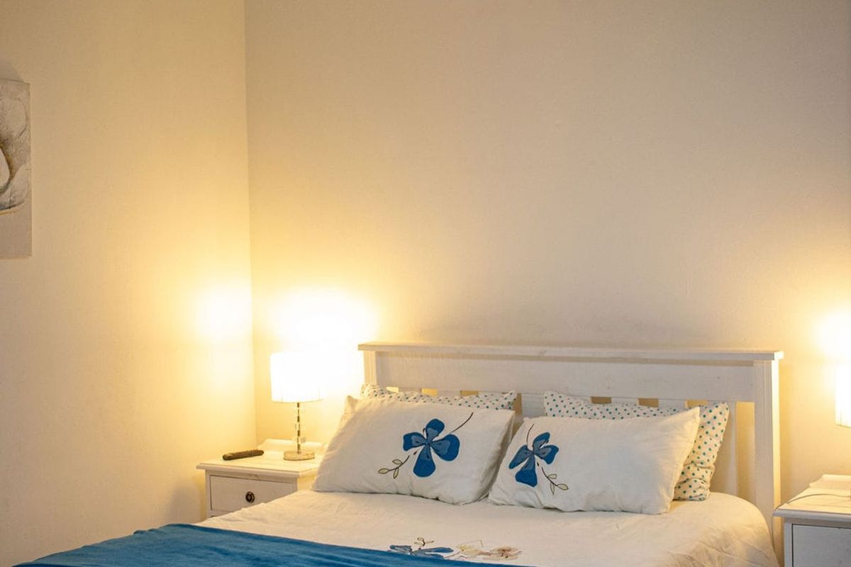 A well-lit bedroom featuring a modern ceiling fan light fixture and tiled flooring.