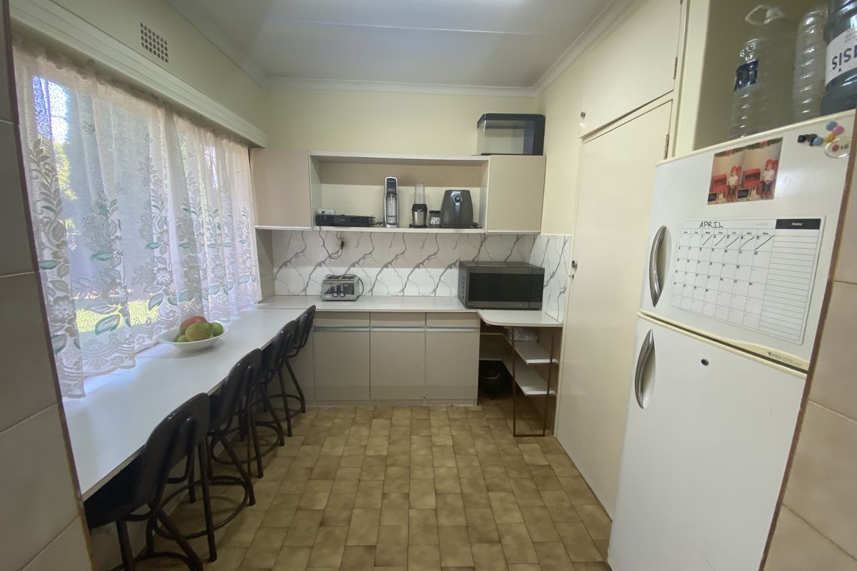 A functional kitchen featuring built-in cabinetry, a breakfast bar, and tiled flooring, offering a practical layout for daily meal preparation.