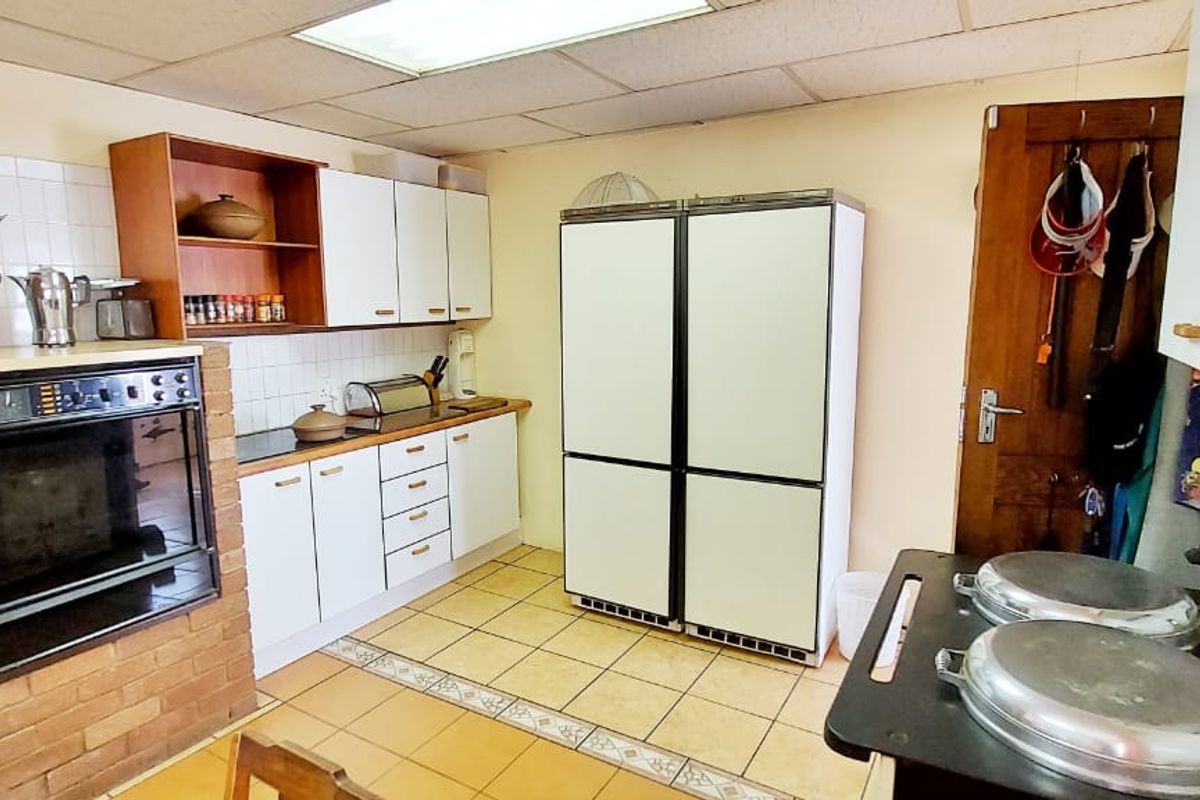 A dated kitchen featuring built-in cabinetry, a brick-encased wall oven, and tiled flooring, offering potential for a modern renovation.