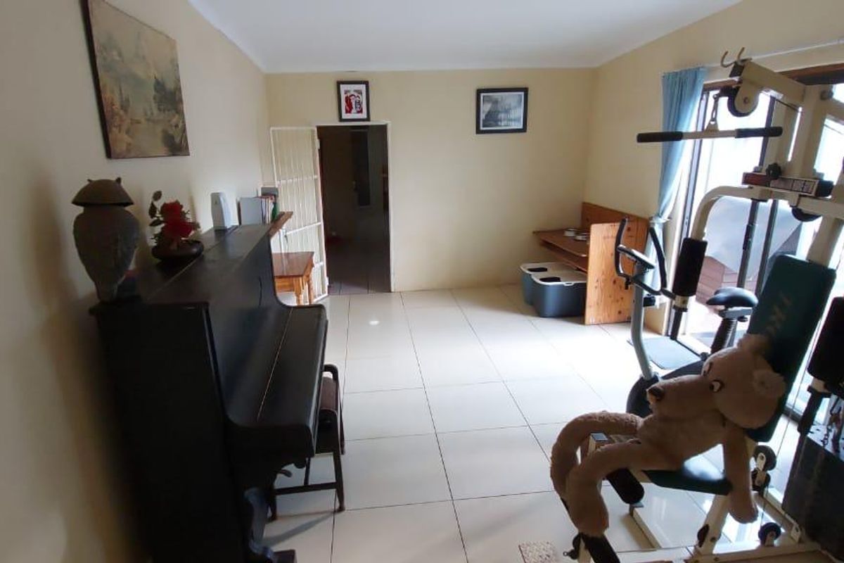 A multi-purpose living area featuring tiled flooring and access to an outdoor space through a sliding glass door.