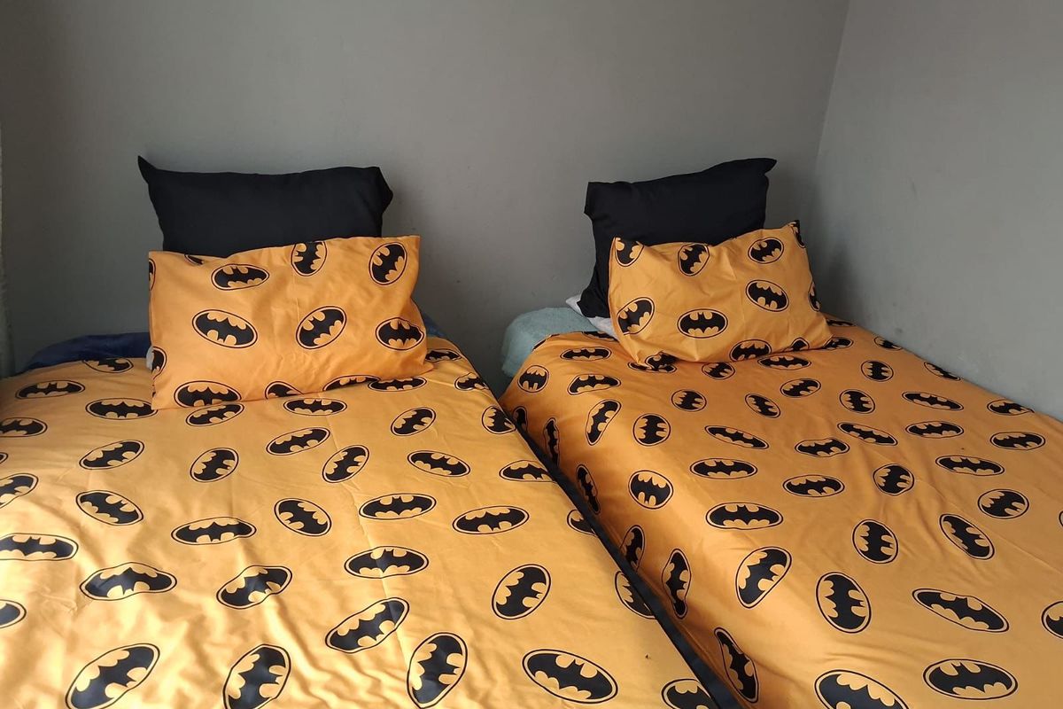 A bedroom featuring two single beds positioned against a plain wall.