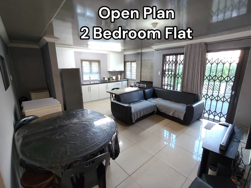 Open plan living and kitchen area featuring tiled floors, built-in cabinetry, gas stove, and sliding doors leading to an outdoor space.