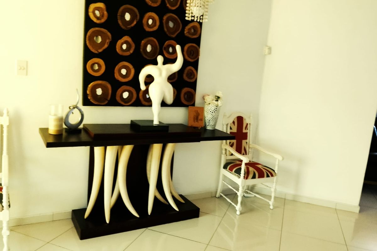 A living area featuring neutral tiled flooring and plain white walls, providing a blank canvas for interior design.