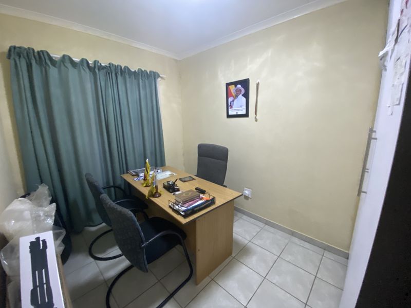 A functional home office space featuring tiled flooring and neutral wall finishes, suitable for a dedicated workspace or study area.