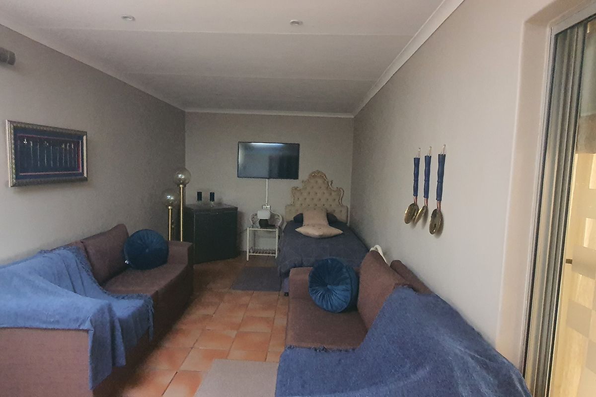 A multi-purpose living space featuring tiled flooring, recessed ceiling lighting, and sliding glass door access to the exterior.