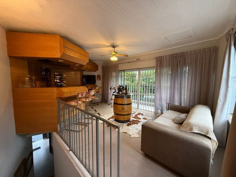 A dedicated bar area featuring built-in wooden cabinetry, a counter, and sliding glass doors leading to an outdoor space.