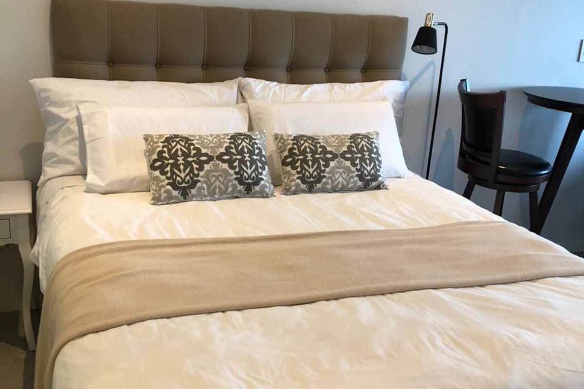 A well-maintained bedroom featuring a neutral color palette and a comfortable sleeping area.