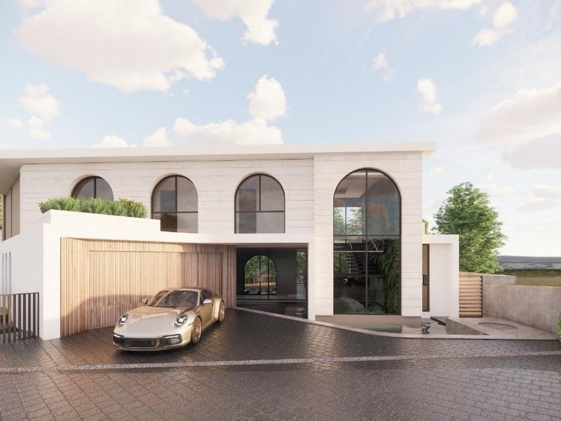 A modern residential exterior featuring arched windows, stone cladding, and a paved driveway with an integrated garage.