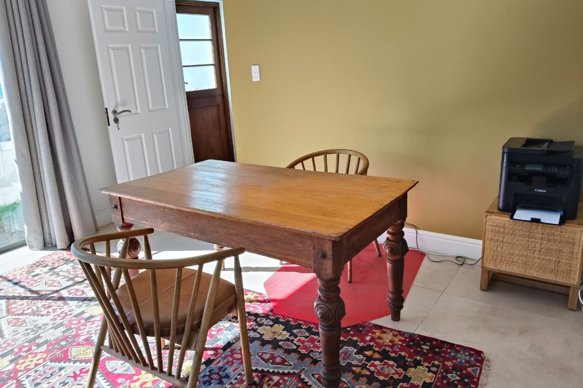 A functional living space featuring tiled flooring, a mustard-toned accent wall, and a classic panelled door leading to an adjacent area.