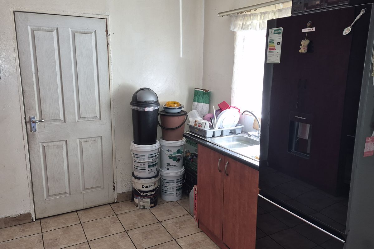 A functional kitchen area featuring a single sink, built-in base cabinetry, and tiled flooring, providing a practical space for daily food preparation.