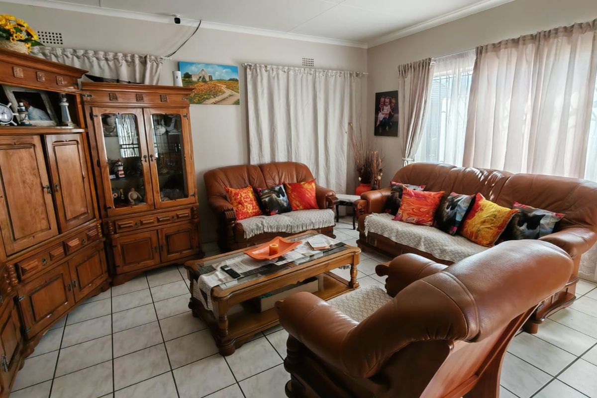 A spacious living room featuring tiled flooring and large windows, providing a comfortable and functional area for relaxation.