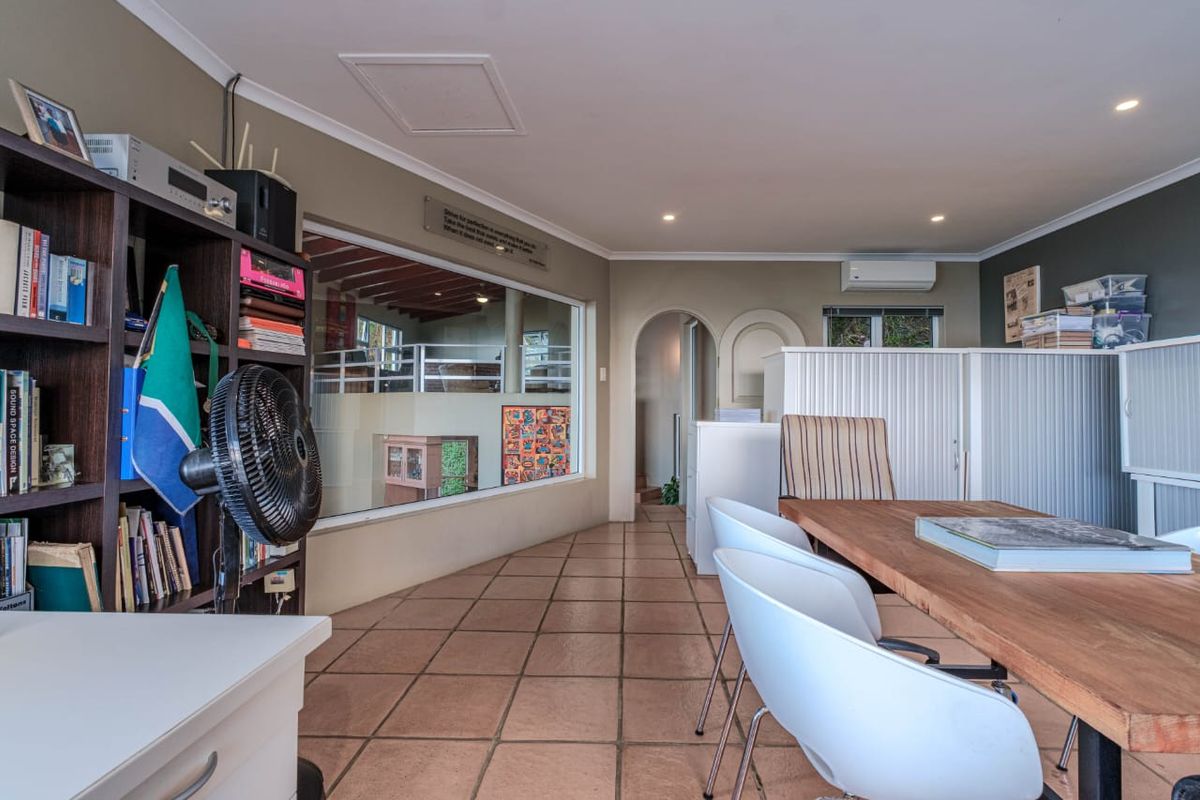 Spacious living area featuring tiled flooring, recessed lighting, and a split-system air conditioner, with an archway leading to adjacent rooms.