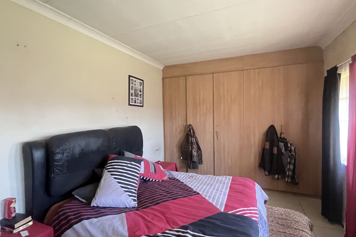 A bedroom featuring built-in wooden cupboards and coved ceilings, offering functional storage space and a neutral foundation for interior updates.