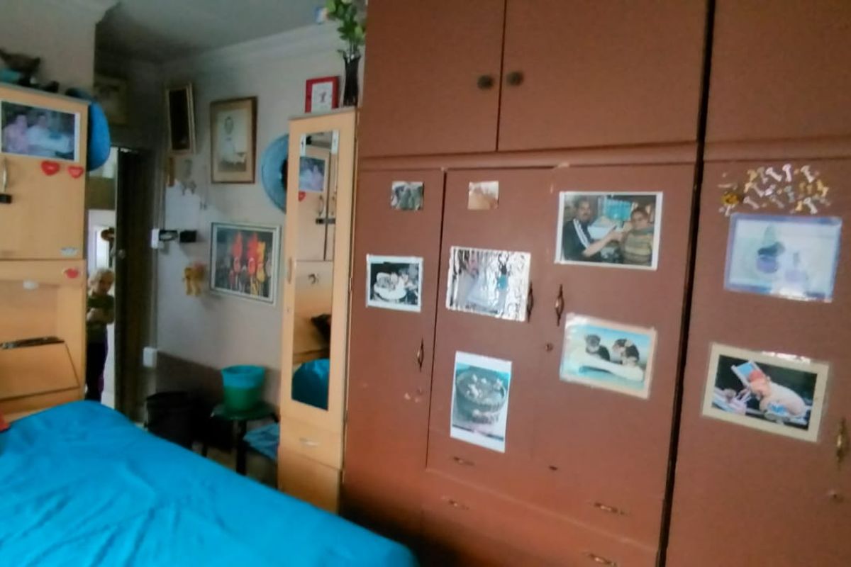 A bedroom featuring extensive built-in wooden cabinetry and storage units, providing ample storage space within the room.