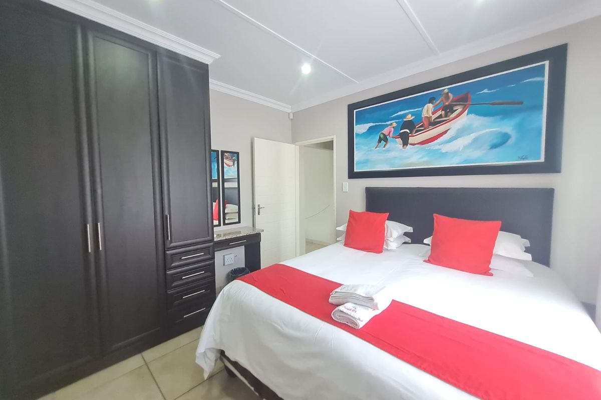 A well-maintained bedroom featuring built-in dark wood cabinetry, tiled flooring, and recessed ceiling lighting.