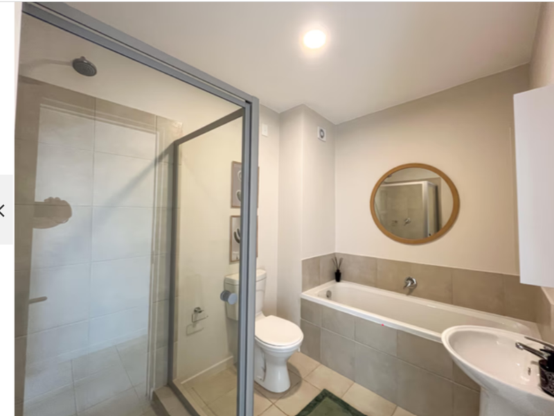 Modern bathroom featuring a glass-enclosed shower, a bathtub with tiled surround, a pedestal basin, and a toilet, finished with neutral wall tones.