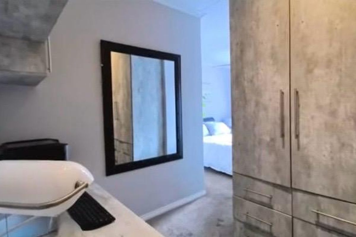 Bedroom featuring built-in cupboards and a built-in desk area with a mirror, providing functional storage and workspace.