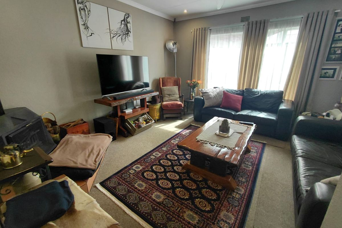 A comfortable living room featuring a built-in fireplace, neutral wall tones, and large windows that provide ample natural light.
