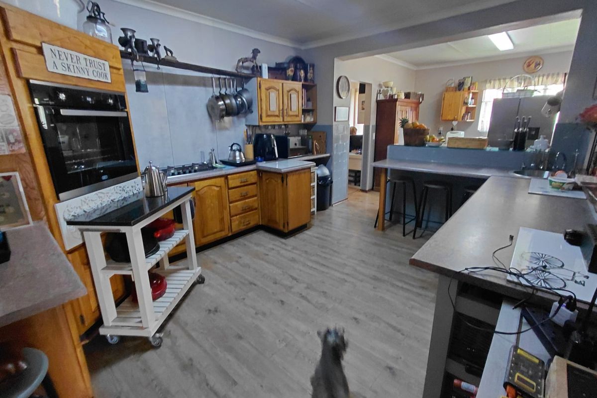 Spacious kitchen featuring wooden cabinetry, built-in oven, and a breakfast bar counter, offering a functional layout with ample workspace.
