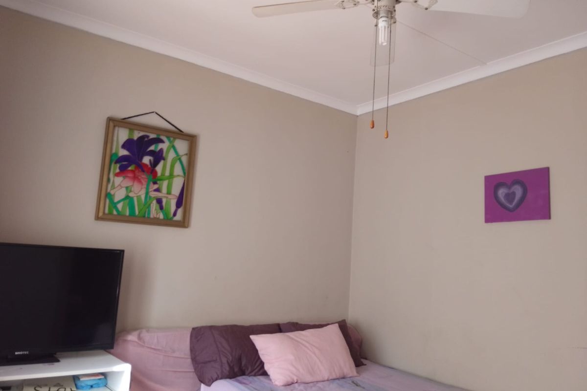 A bedroom featuring neutral wall tones, a ceiling fan, and coved cornicing.