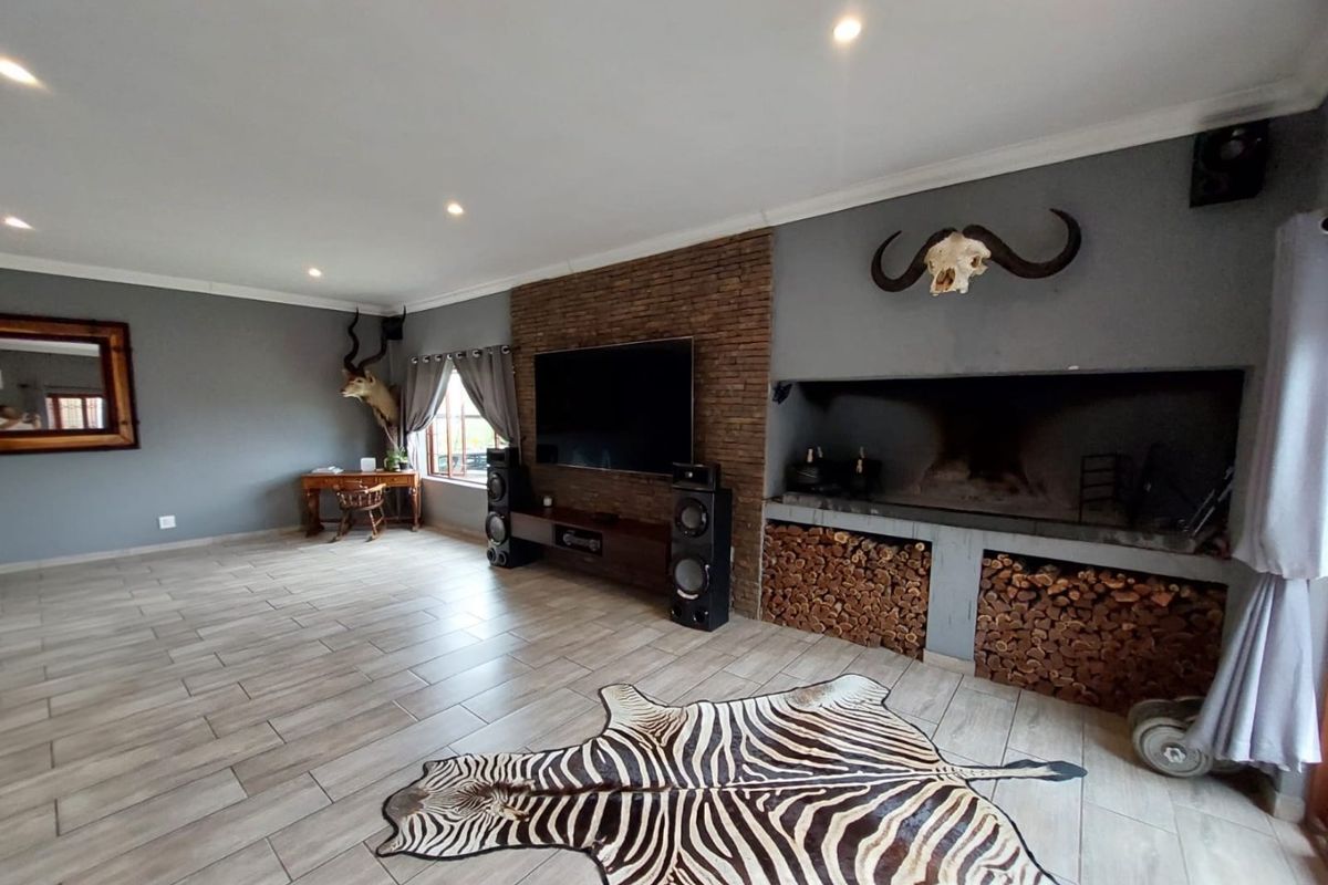 Spacious living room featuring a prominent brick feature wall, built-in fireplace with integrated wood storage, and modern tiled flooring.