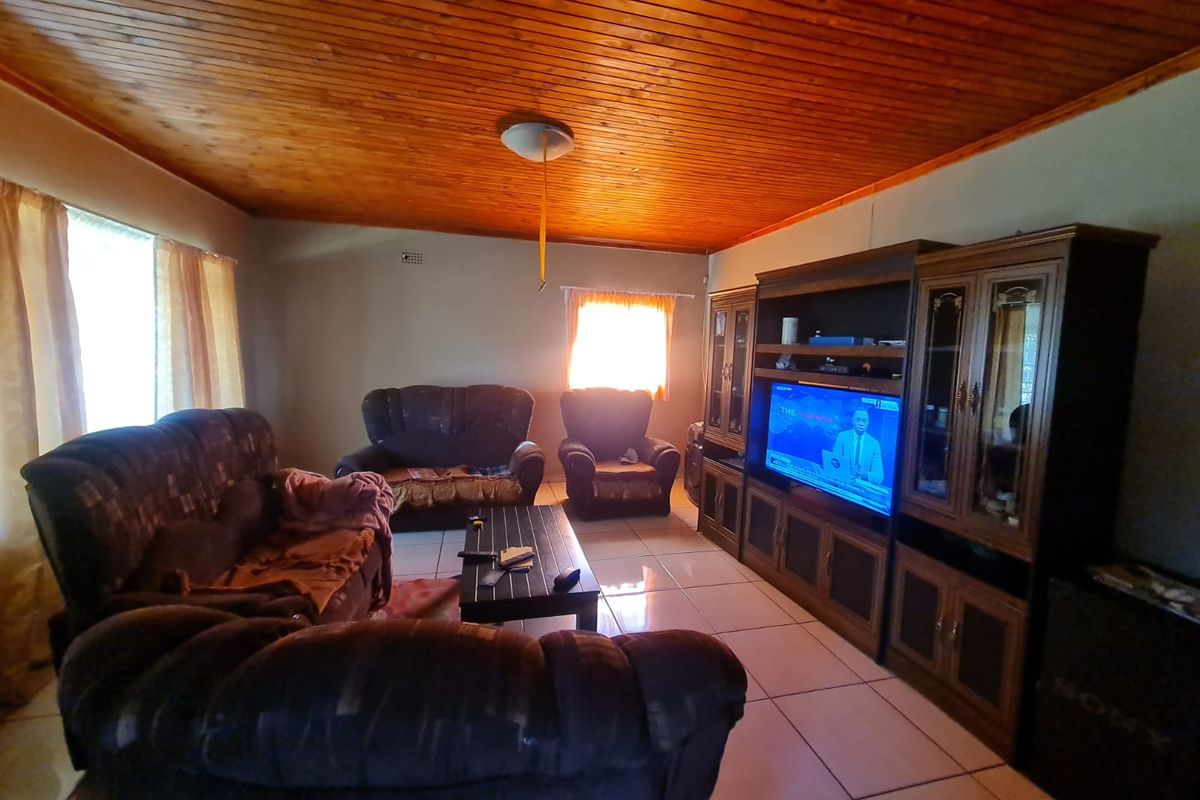 A living room featuring tiled flooring and a distinctive timber-clad ceiling, providing a warm and traditional aesthetic.