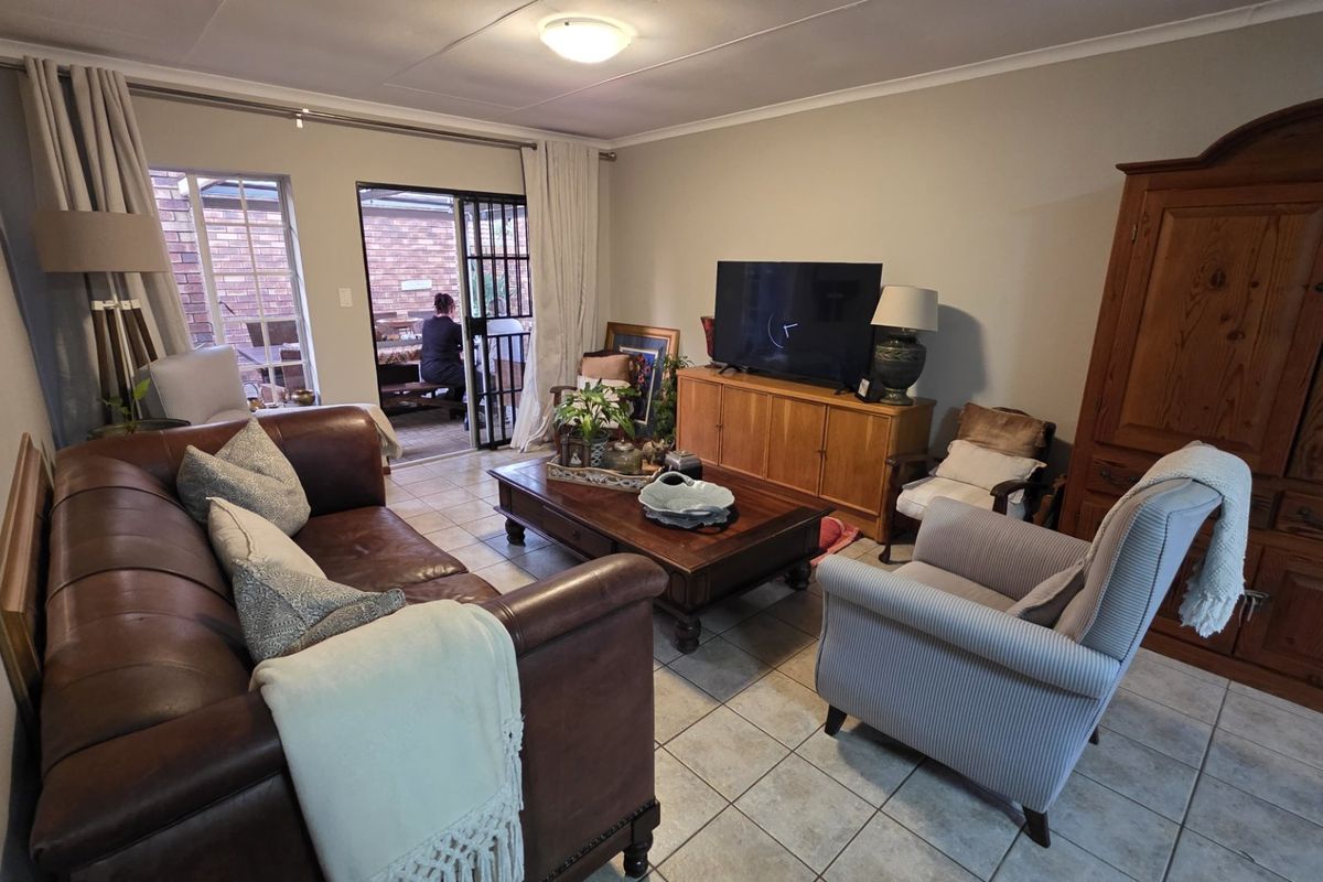 A comfortable living room featuring tiled flooring and sliding glass doors that provide direct access to an outdoor patio area.