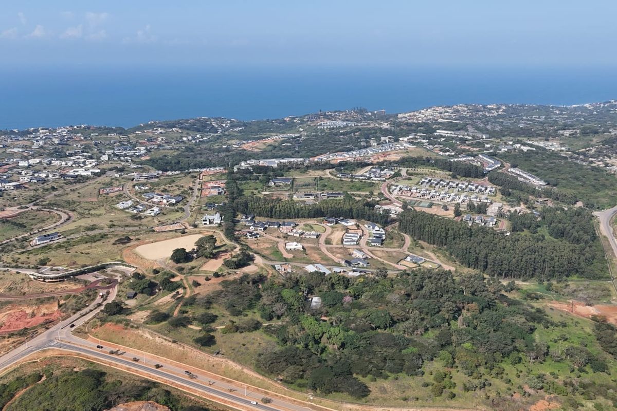 An expansive aerial view of the residential estate, showcasing the surrounding landscape, coastal proximity, and established road infrastructure.
