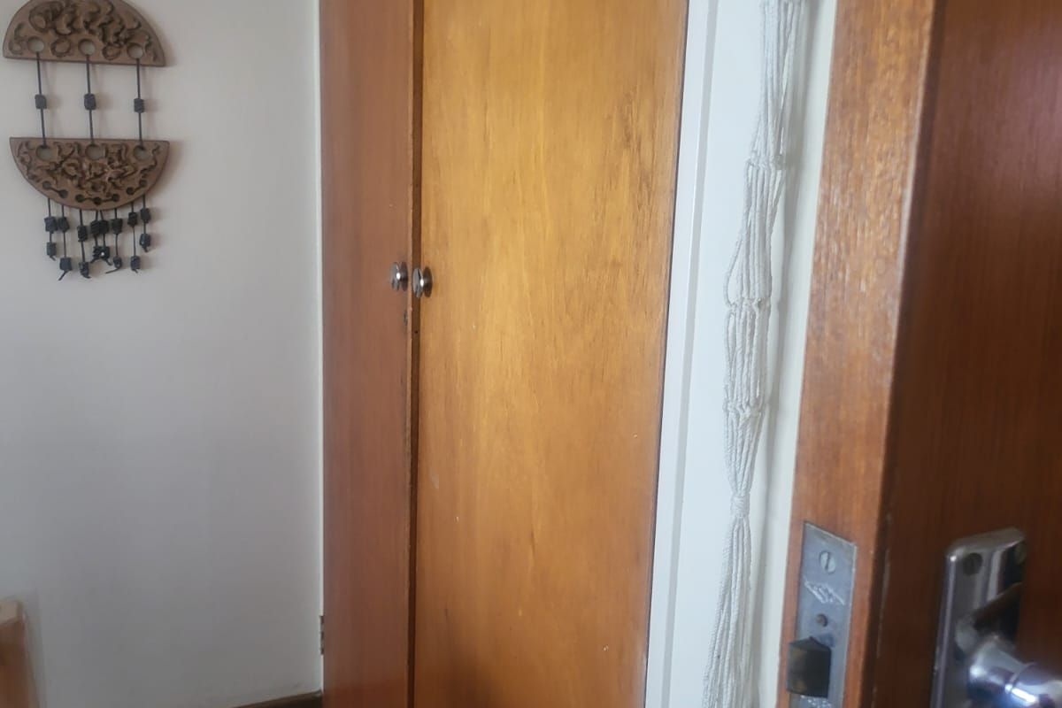 A bedroom interior featuring built-in wooden cupboards and carpeted flooring.